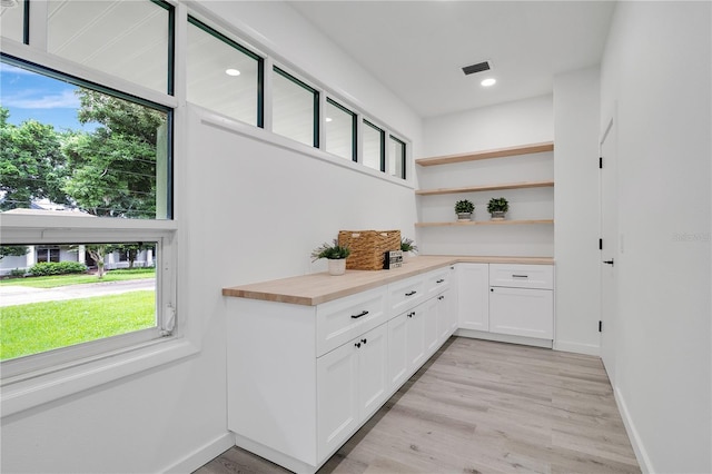 bar featuring healthy amount of natural light, baseboards, light wood-style flooring, and recessed lighting
