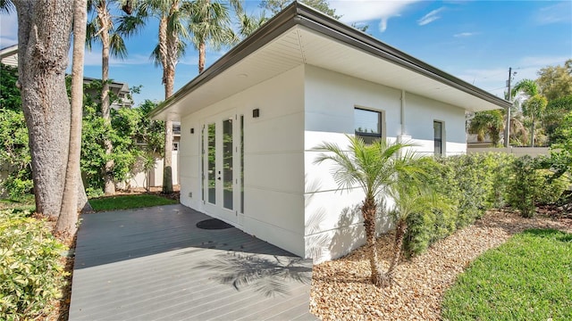 view of side of home with french doors and a wooden deck