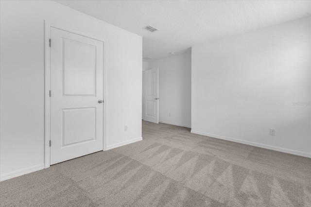 carpeted empty room with baseboards and visible vents