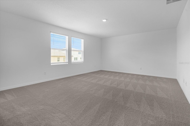 carpeted spare room featuring baseboards