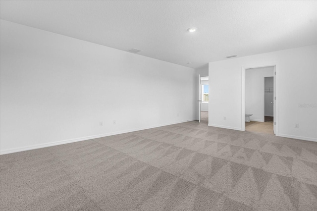 unfurnished room featuring visible vents, baseboards, recessed lighting, a textured ceiling, and light carpet