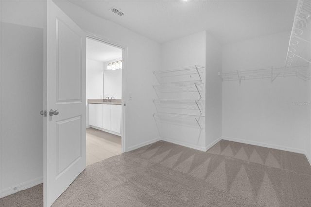 spacious closet featuring visible vents and carpet flooring