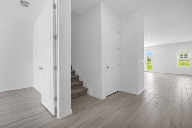 stairs with visible vents, baseboards, and wood finished floors