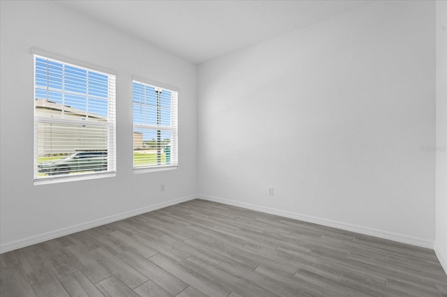 unfurnished room with baseboards and wood finished floors