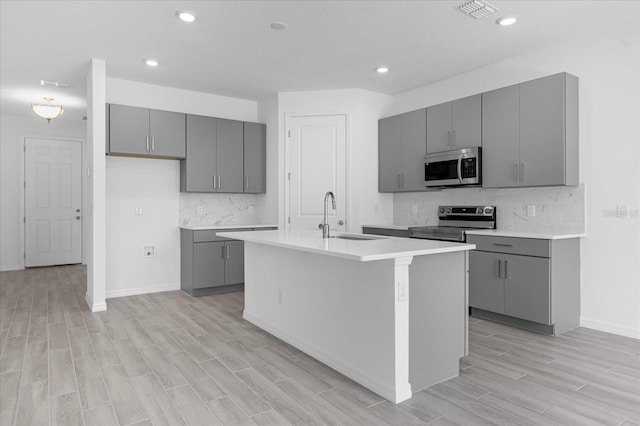 kitchen featuring a sink, visible vents, gray cabinets, and stainless steel appliances