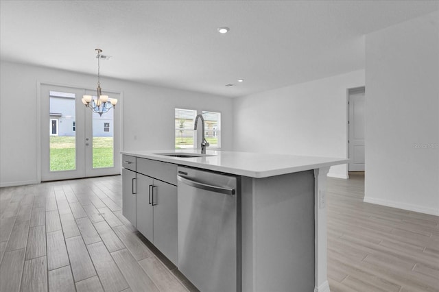 kitchen featuring wood tiled floor, a sink, light countertops, dishwasher, and a notable chandelier