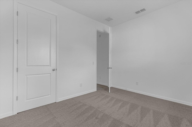 unfurnished bedroom with carpet, visible vents, and baseboards