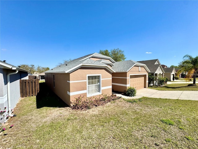 view of front facade with a front yard, fence, stucco siding, concrete driveway, and a garage