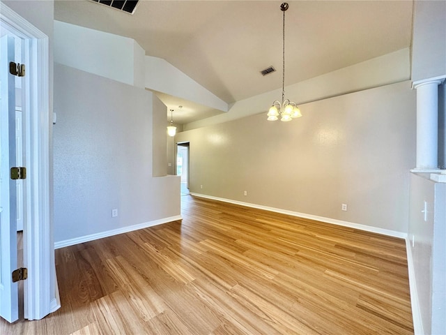 spare room with visible vents, lofted ceiling, light wood finished floors, baseboards, and a chandelier