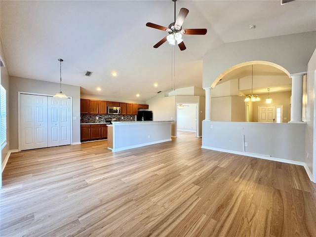 unfurnished living room with decorative columns, light wood-style floors, visible vents, and ceiling fan