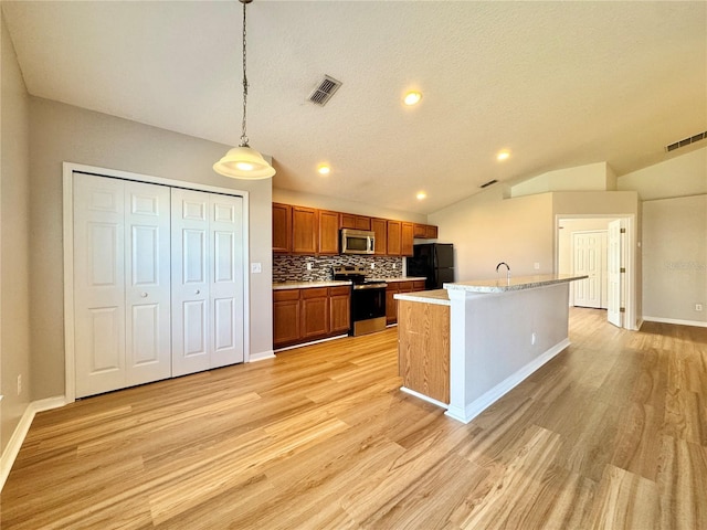 kitchen featuring visible vents, tasteful backsplash, appliances with stainless steel finishes, brown cabinetry, and lofted ceiling