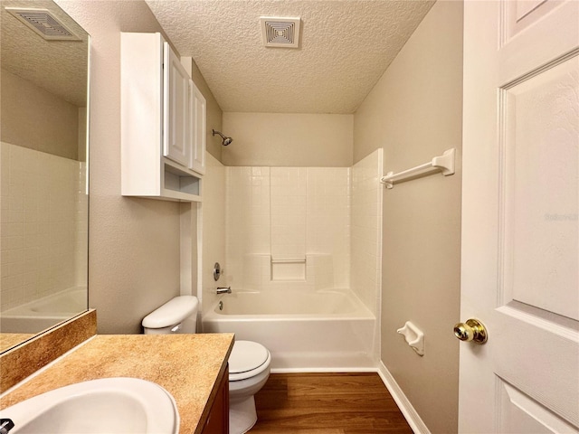 full bath featuring vanity, wood finished floors, visible vents, a textured ceiling, and toilet