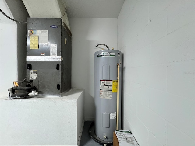 utility room with heating unit and electric water heater