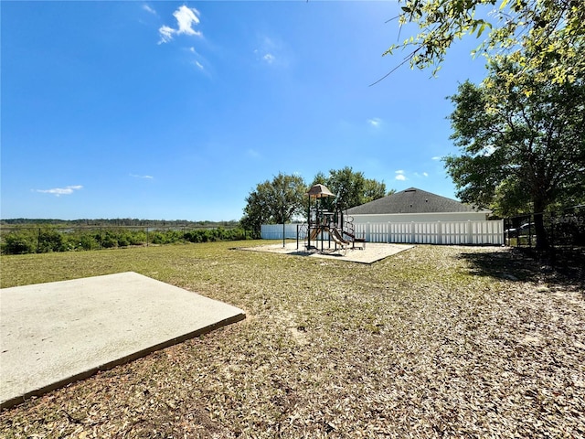 view of yard with a patio area, a playground, and fence