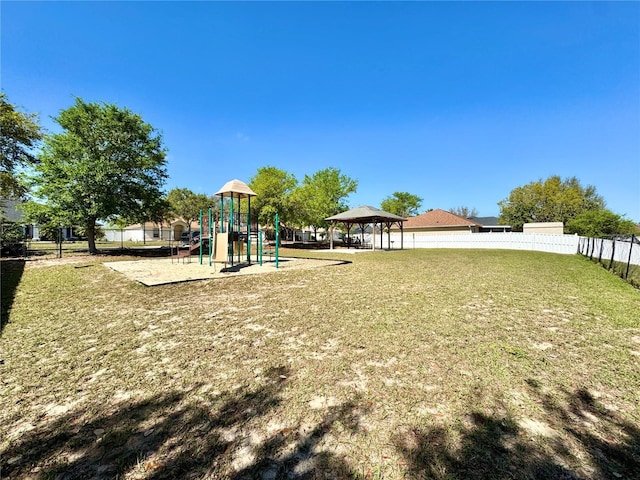 community play area with a gazebo, a yard, and fence