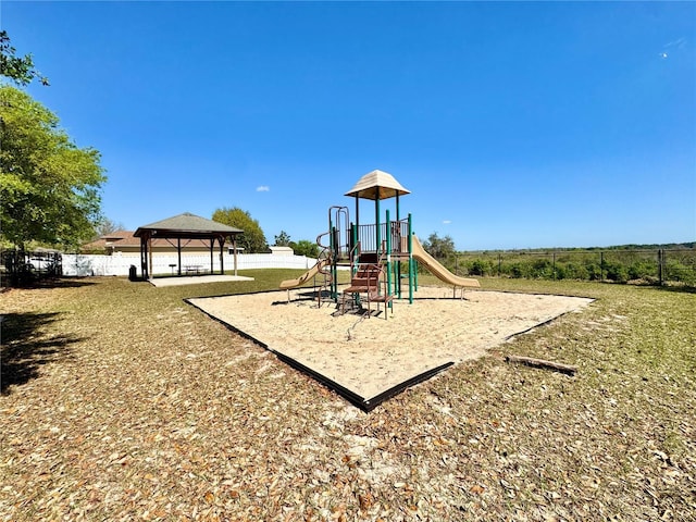 communal playground featuring a gazebo and fence