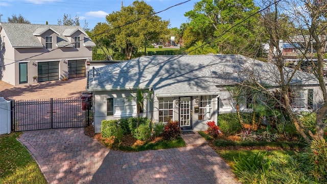 view of front of house featuring stucco siding, driveway, fence, and a gate