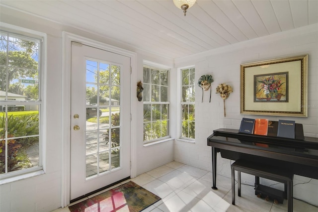 entryway with a wealth of natural light, light tile patterned flooring, and wooden ceiling