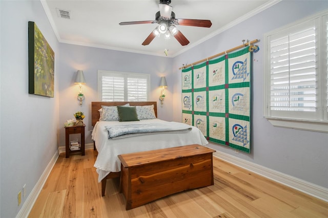 bedroom with a ceiling fan, baseboards, visible vents, ornamental molding, and light wood-type flooring