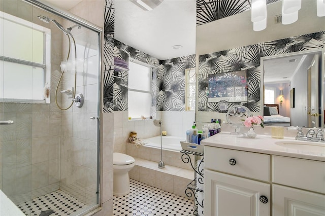 full bathroom featuring a bath, a shower stall, wallpapered walls, and vanity