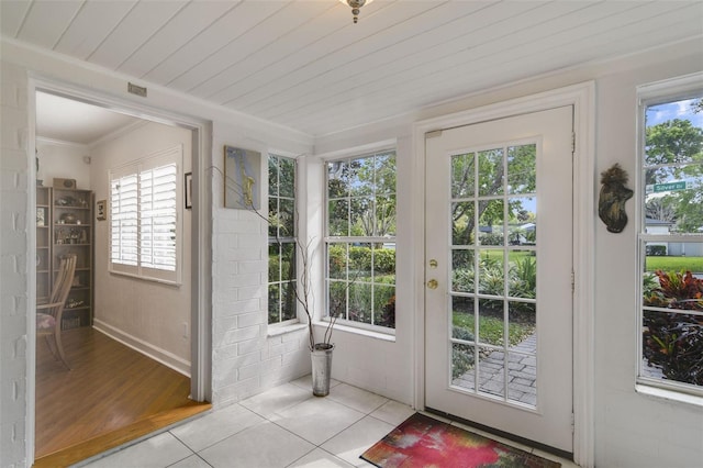 doorway to outside with crown molding, wooden ceiling, and tile patterned floors