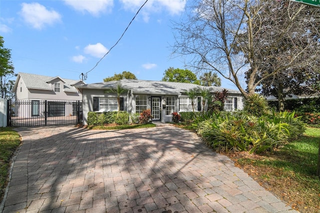 single story home with stucco siding, fence, and a gate