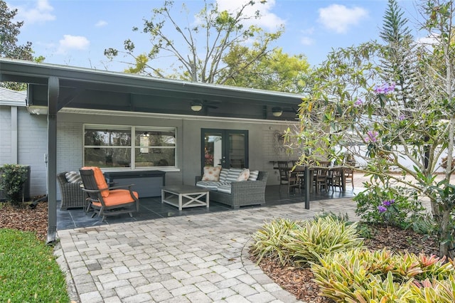 back of property with brick siding, french doors, outdoor lounge area, a patio area, and a ceiling fan