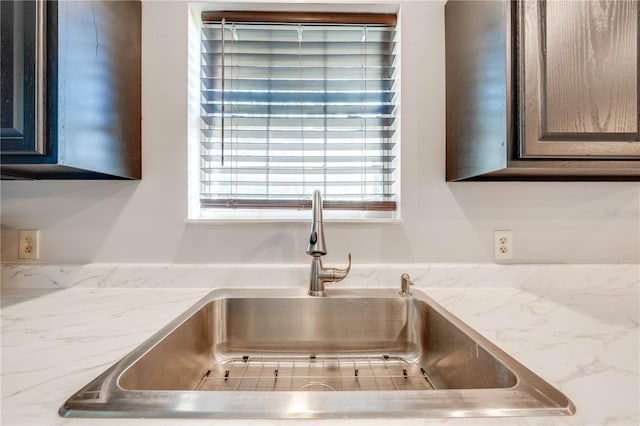 room details with a sink and light stone countertops