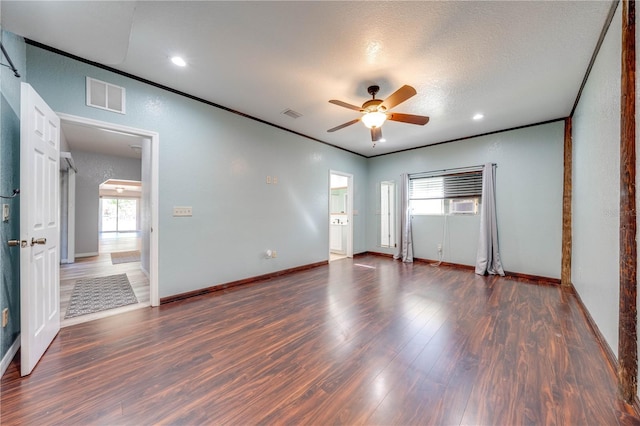 unfurnished room with visible vents, wood finished floors, ornamental molding, and a ceiling fan