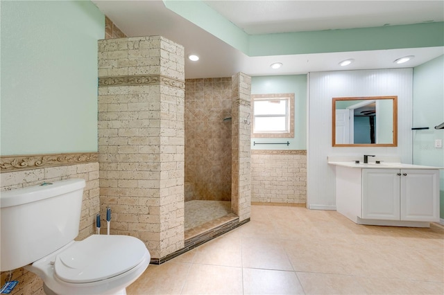 bathroom with toilet, a walk in shower, recessed lighting, tile patterned flooring, and vanity