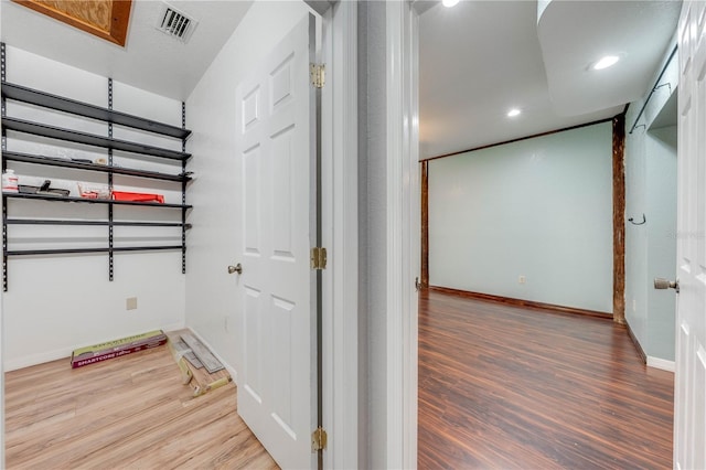 corridor featuring recessed lighting, wood finished floors, visible vents, and baseboards