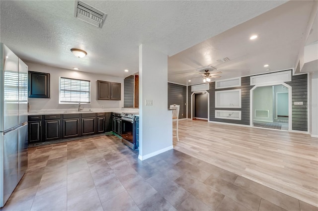 kitchen with visible vents, light countertops, stainless steel appliances, a ceiling fan, and a sink