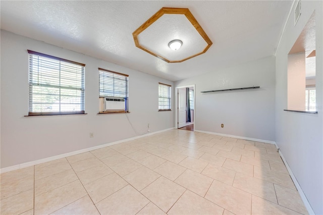 unfurnished room with light tile patterned floors, visible vents, baseboards, and a textured ceiling