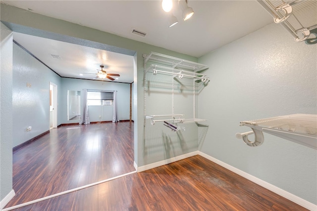 spacious closet featuring visible vents, a ceiling fan, and wood finished floors