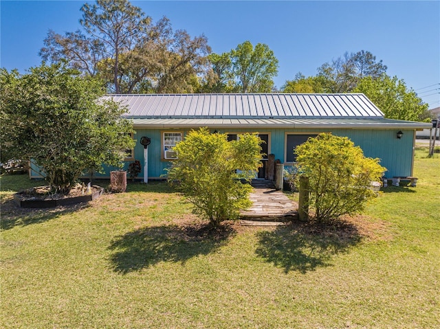 back of property featuring a standing seam roof, a yard, and metal roof