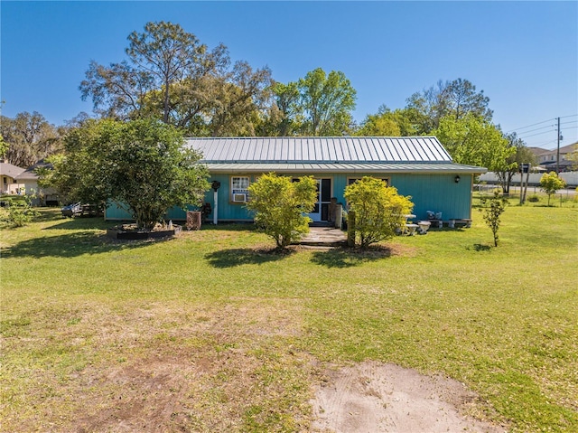 view of front facade with a standing seam roof, metal roof, and a front yard