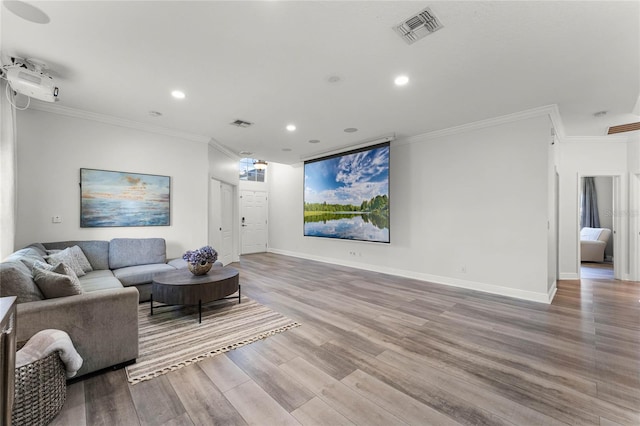 living room featuring visible vents, crown molding, baseboards, and wood finished floors