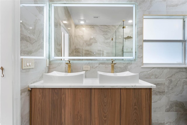 full bath featuring a sink and tile walls