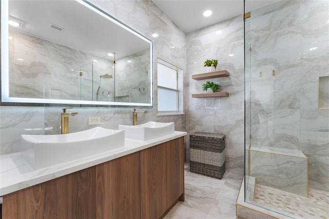 bathroom featuring a marble finish shower, marble finish floor, and a sink