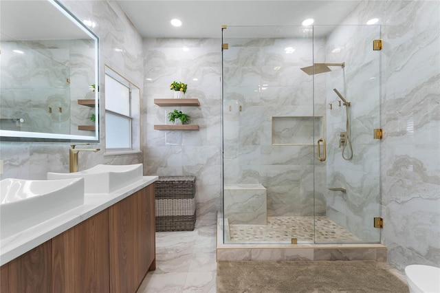 full bath featuring vanity, tile walls, a stall shower, and marble finish floor