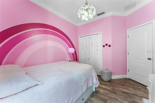 bedroom with visible vents, wood finished floors, a chandelier, and crown molding