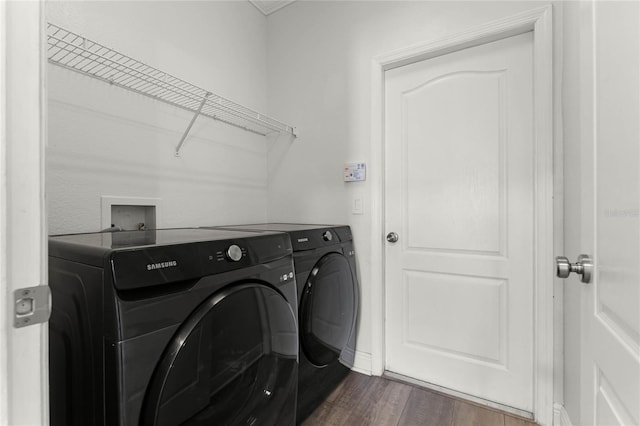 clothes washing area featuring washer and clothes dryer, laundry area, and dark wood-style floors