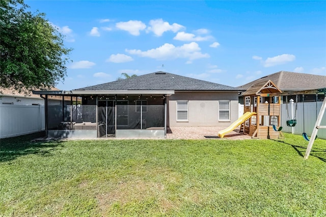 back of house featuring a yard, a playground, a fenced backyard, and a sunroom