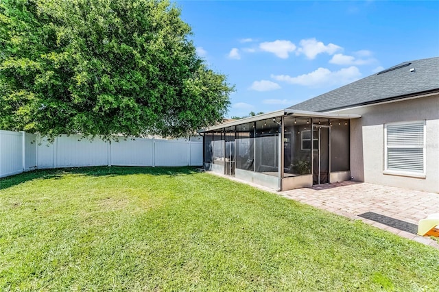 view of yard featuring a patio area, a fenced backyard, and a sunroom