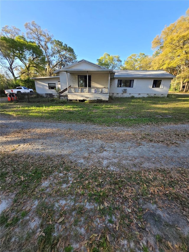 view of front facade with crawl space, a porch, and a front lawn