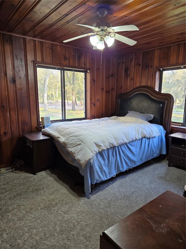 bedroom with multiple windows, wooden walls, and wooden ceiling