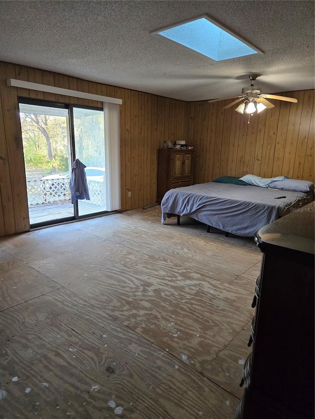 unfurnished bedroom with access to exterior, a textured ceiling, and a skylight