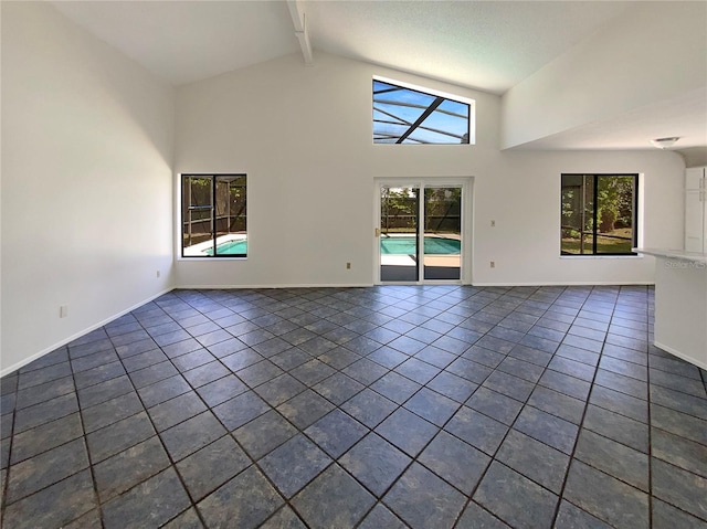 spare room with dark tile patterned flooring, baseboards, beamed ceiling, and high vaulted ceiling