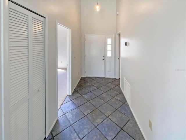 interior space featuring baseboards and a high ceiling