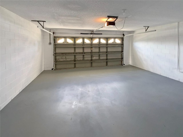 garage with concrete block wall and a garage door opener